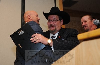 Steve Austin hugs Jim Ross after Ross introduced him. Co-emcee Terry Funk looks on. Photo by Scott Romer