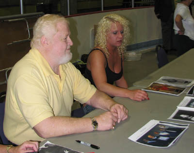 Larry Hennig signs autographs with his granddaughter, Amy, at a WLW show in Waterloo, Iowa, in July 2008. Photo by Greg Oliver.