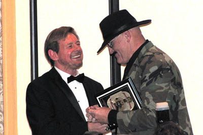 Roddy Piper and Sgt. Slaughter at the podium as Sarge get the Iron Mike Award. Photo by Steven Johnson.