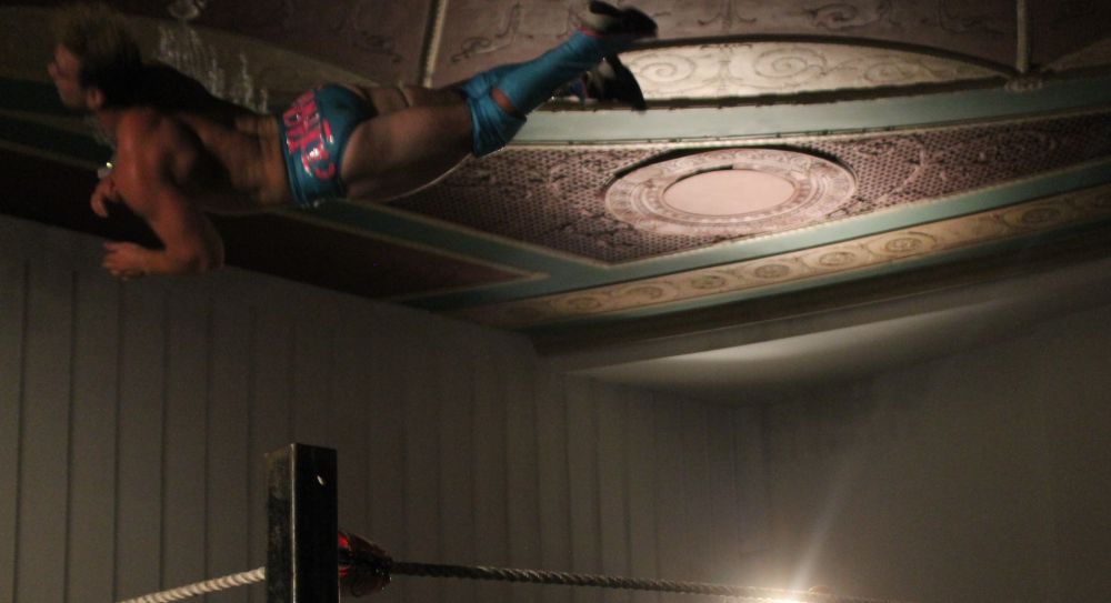 Jack Cartwheel gets in the way of a swell photo of the beautiful ceiling at Parkdale Hall during Demand Lucha on June 29, 2023, in Toronto, Ontario. Photo by Greg Oliver