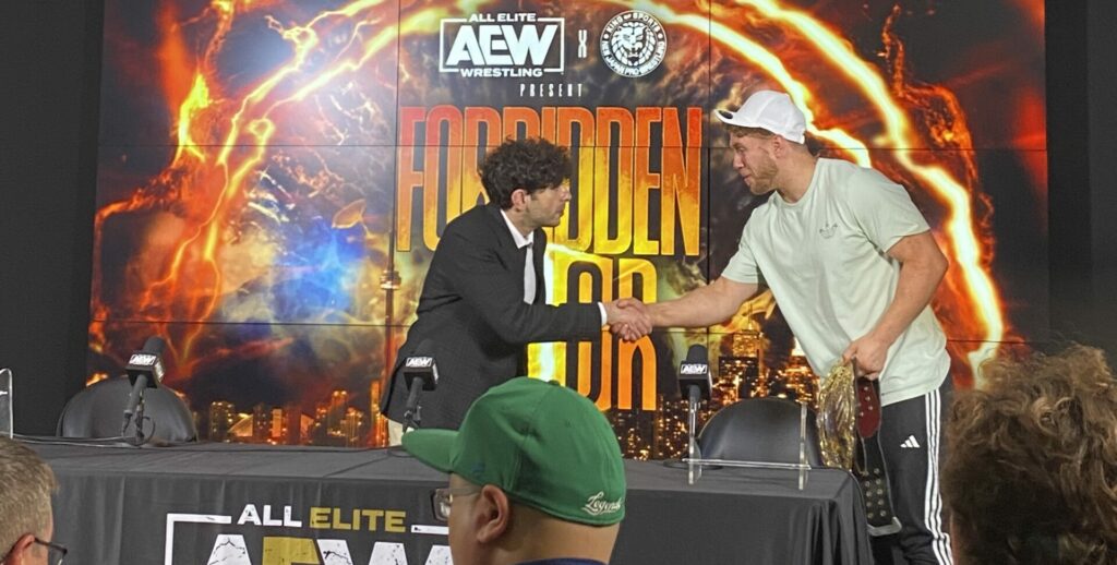 New IWGP United States Heavyweight Champion, Will Ospreay, shakes the hand of AEW President Tony Khan at the Forbidden Door media scrum in Toronto.