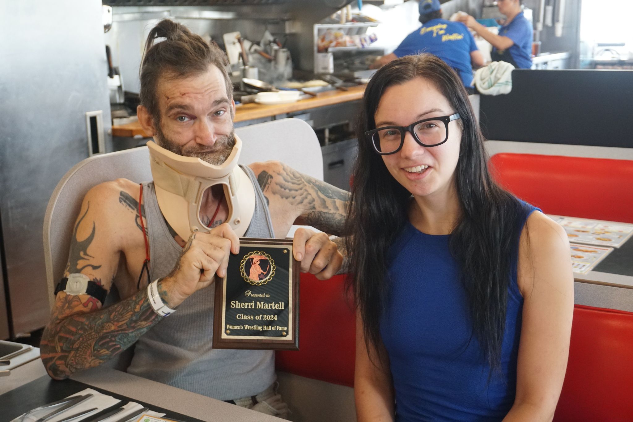 Journalist Vanessa Marchewka presents the Women's Wrestling Hall of Fame plaque to Jarred Gonzales, the son of Sherri Martel, in New Orleans.