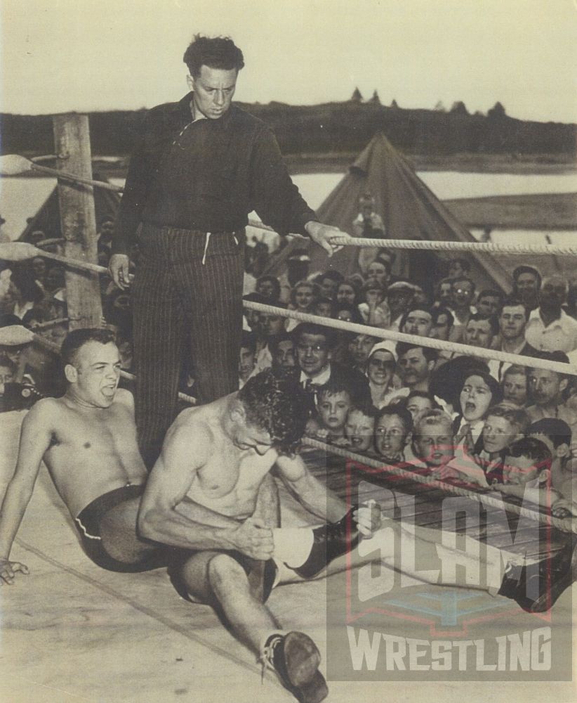 Al Zinck in action, as he is being bent by Ron "Bingo" Mayfield as referee Curly Aguire looks on, during matches held at the "Dockyard Picnic" in 1949.