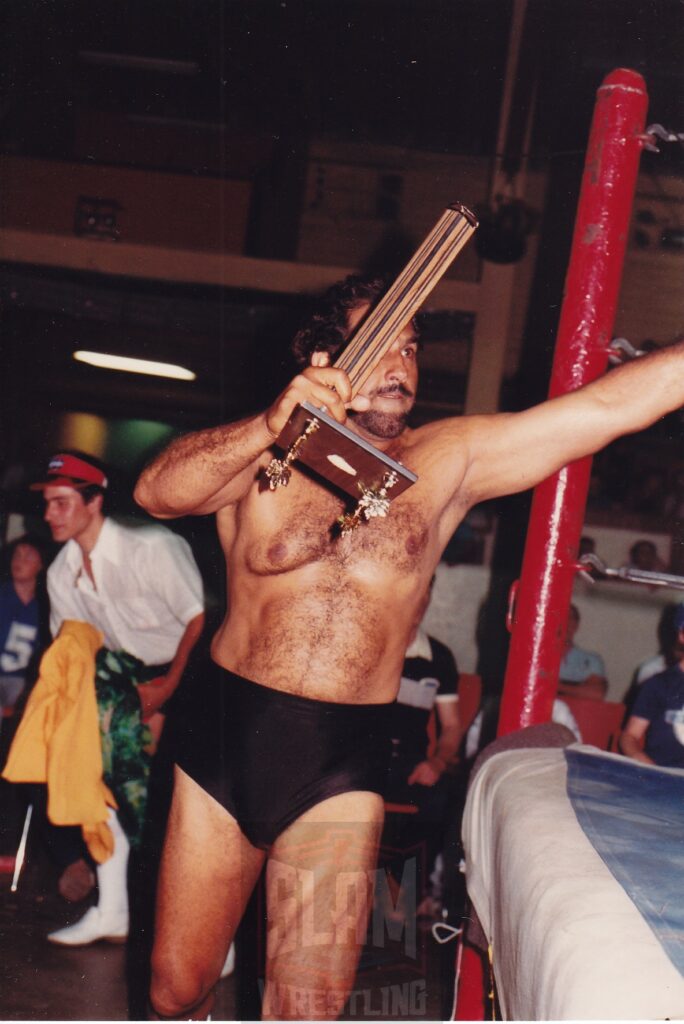 Tiger Jeet Singh, with broken trophy, heads back into the ring. Photo by Terry Dart