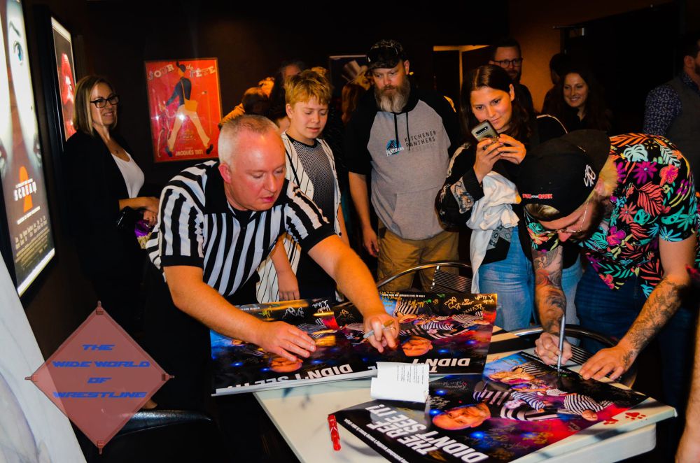 Participants sign the movie poster at the advance screening of The Ref Didn't See it on Thursday, October 3, 2024, at the Apollo Theatre in Kitchener, Ontario. Photo courtesy The Wide World Of Wrestling podcast, https://x.com/THEWWOWPodcast