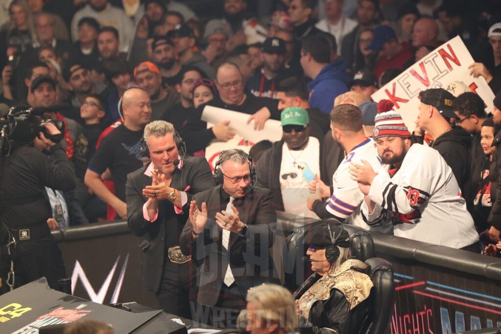 Pat McAfee and Michael Cole applaud Jesse “The Body” Ventura after he joins them at the ringside announce position at WWE Saturday Night's Main Event on Saturday, December 14, 2024, at the Nassau Veterans Memorial Coliseum in Uniondale, New York. Photo by George Tahinos, georgetahinos.smugmug.com