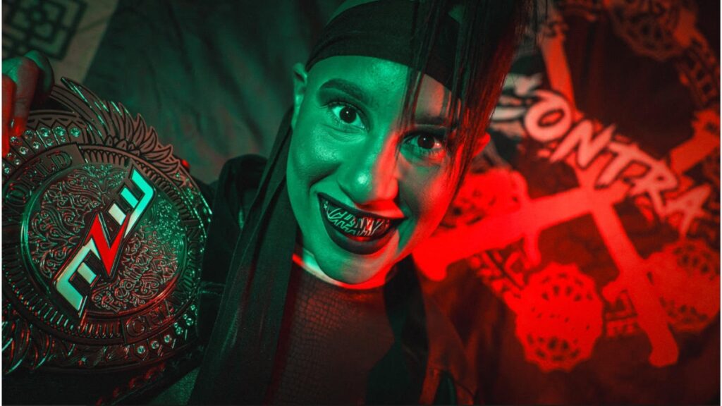 MLW Featherweight Champion Janai Kai poses with her title belt, with her faction name in the background. Photo courtesy of MLW.