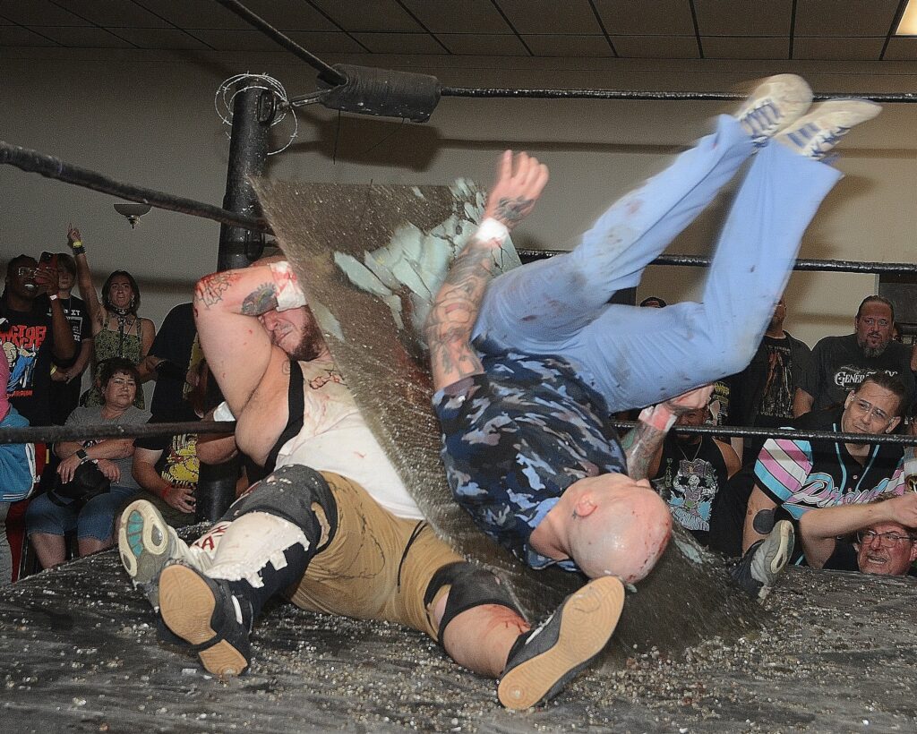 Dr Redacted falls through glass on Tommy Trainwreck at Horror Slam at the Elk's Lodge on September 13, 2024. Photo by Brad McFarlin. 